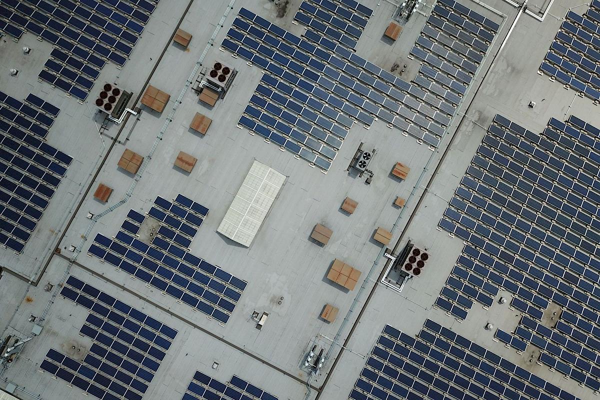Luftaufnahme eines Gewerbedachs mit großflächiger Photovoltaikanlage